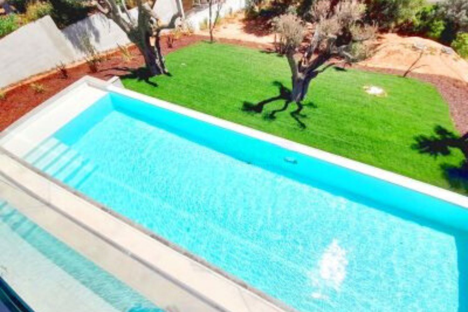 magnifique piscine bleue avec jardin vert