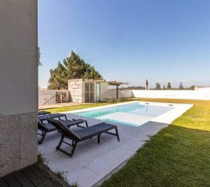 belle vue de la maison avec piscine et jardin
