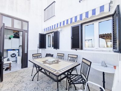 petite terrasse blanche avec une table et des chaises